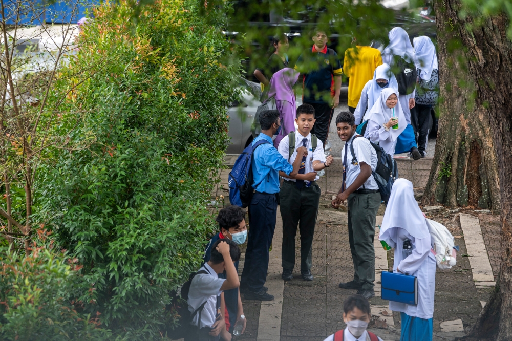 File picture of students waiting for their parents after a school session in Kuala Lumpur, September 27, 2022. According to the author, school spot-checks resemble airport security and prison, teaching prefects to take things away from innocent people without their consent. — Picture by Shafwan Zaidon
