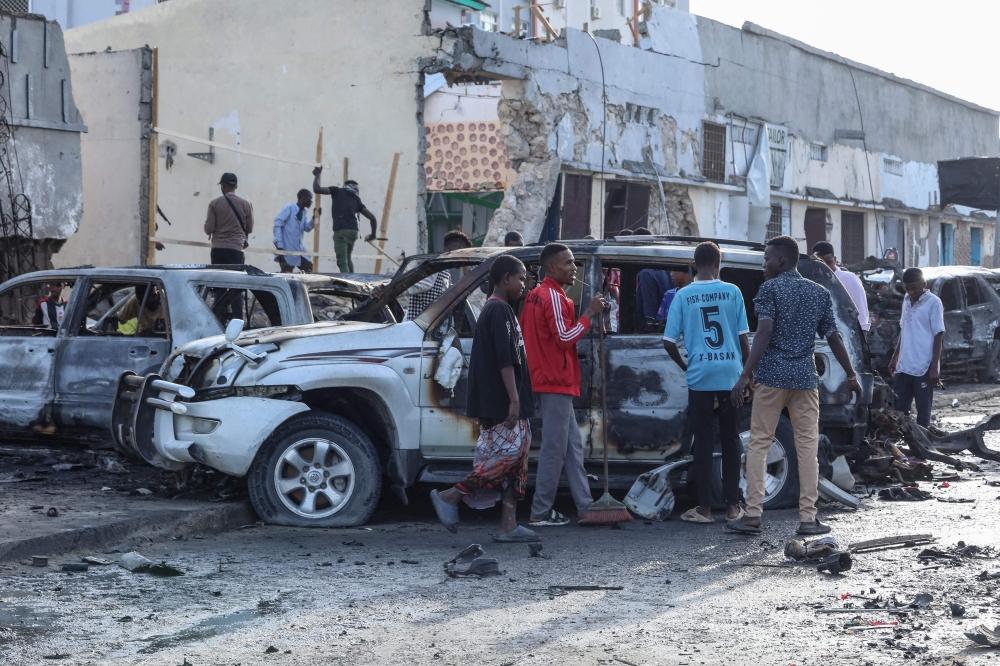 A group of people look at the debris and destruction at a cafe in Mogadishu on July 15, 2024 following a car bomb blast where five people were killed where football fans were watching the Euro 2024 final. — AFP pic