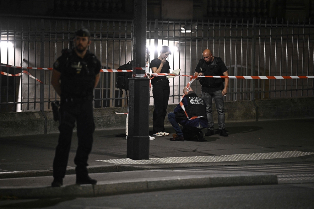 Police officers stand inside a security perimeter outside the Gare de l’Est train station, after an Operation Sentinel soldier was wounded in the shoulder by a knife-wielding man, in Paris July 15, 2024. — AFP pic
