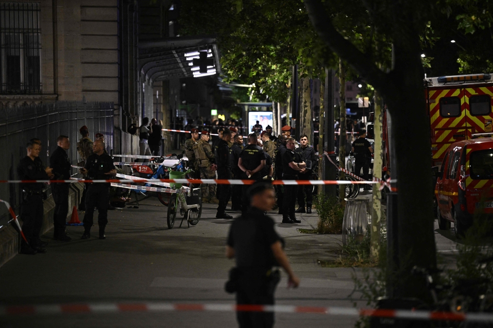 French firefighters and soldiers stand inside a security perimeter outside the Gare de l’Est train station, after an Operation Sentinel soldier was wounded in the shoulder by a knife-wielding man, in Paris July 15, 2024. — AFP pic