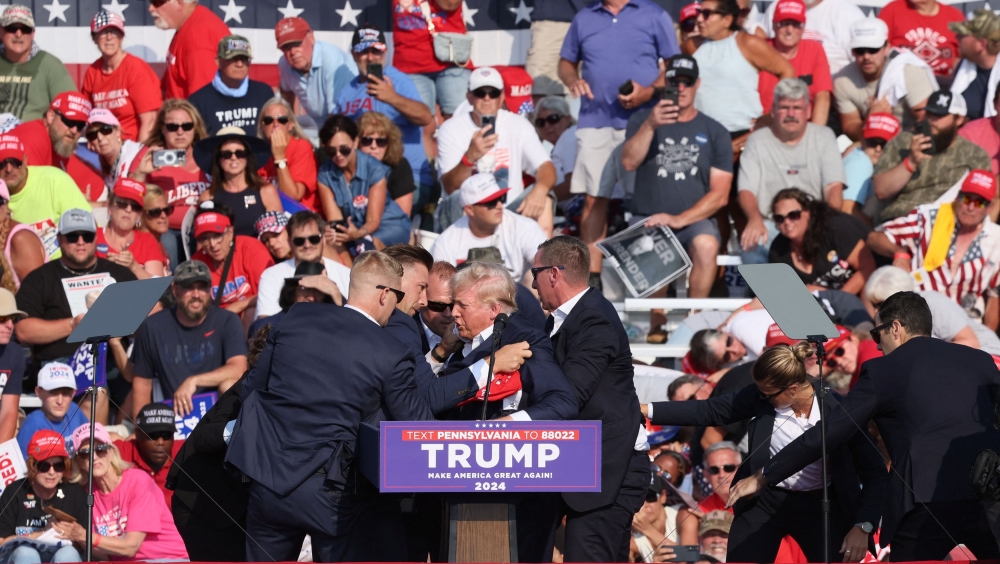 Republican presidential candidate and former US President Donald Trump is assisted by US Secret Service personnel after he was shot in the right ear during a campaign rally at the Butler Farm Show in Butler, Pennsylvania July 13, 2024. — Reuters pic  