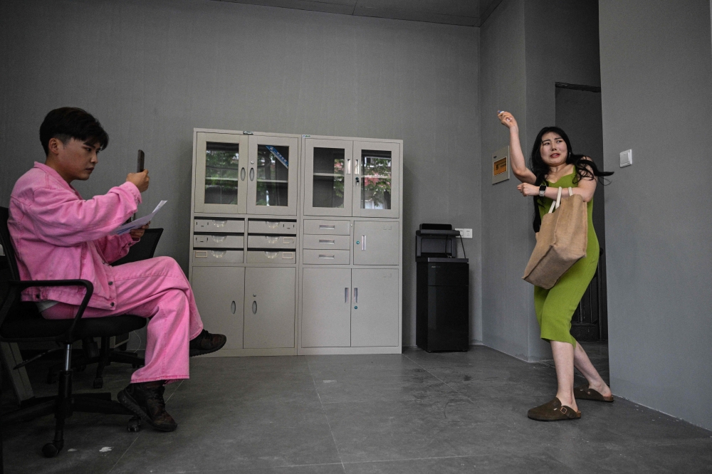 This photo taken on June 18, 2024 shows actress Guo Ting (right) performing during an audition in Hengdian in east China’s Zhejiang Province. Braving loneliness, tough auditions and an unfamiliarly hot and humid climate, aspiring actor Guo Ting is determined to make it in China’s answer to Hollywood. — AFP pic