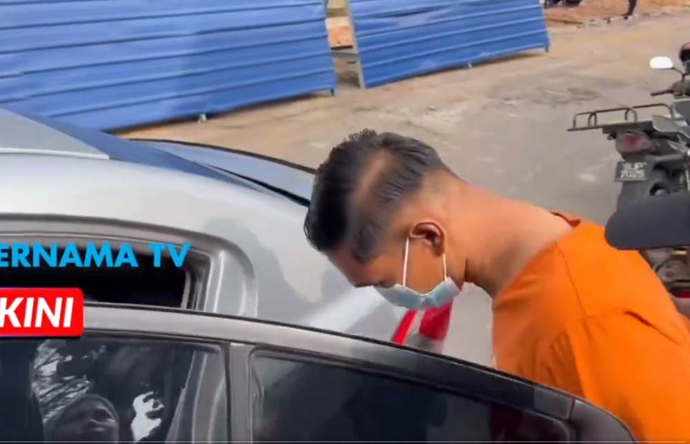 The suspect, dressed in police lockup attire, enters a police vehicle at the Kuala Kubu Baru Court, July 16, 2024. — Screengrab from X/Bernama TV 