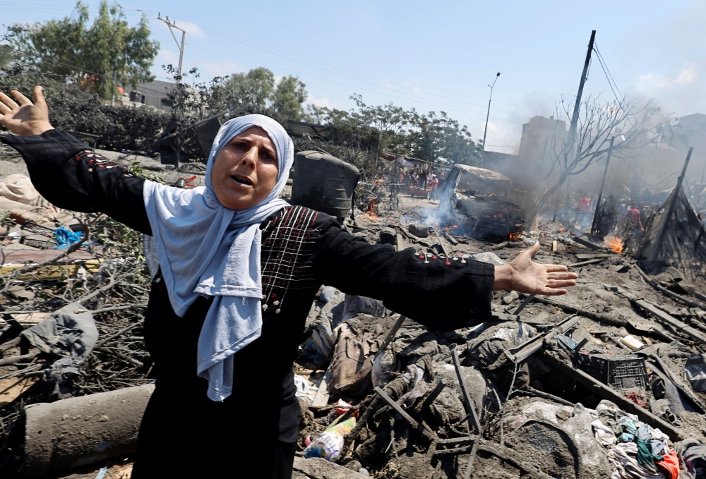 A Palestinian woman reacts near damages, following what Palestinians say was an Israeli strike at a tent camp in Al-Mawasi area, amid Israel-Hamas conflict, in Khan Younis in the southern Gaza Strip July 13, 2024. — Reuters pic  