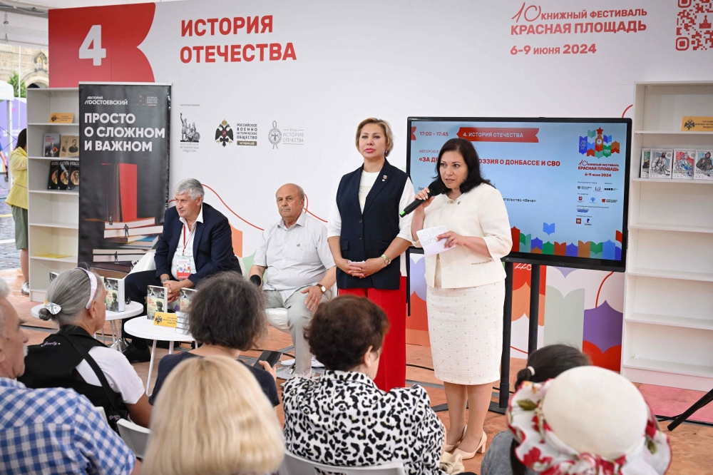 Nina Popova (centre), a poet and the deputy head of the Russian Writers' Union, presents an anthology of patriotic poems entitled ‘For Our Friends’ celebrating the courage of Russian soldiers fighting in Ukraine, during the 10th edition of the ‘Red Square’ book festival in Moscow on June 6, 2024. — AFP pic