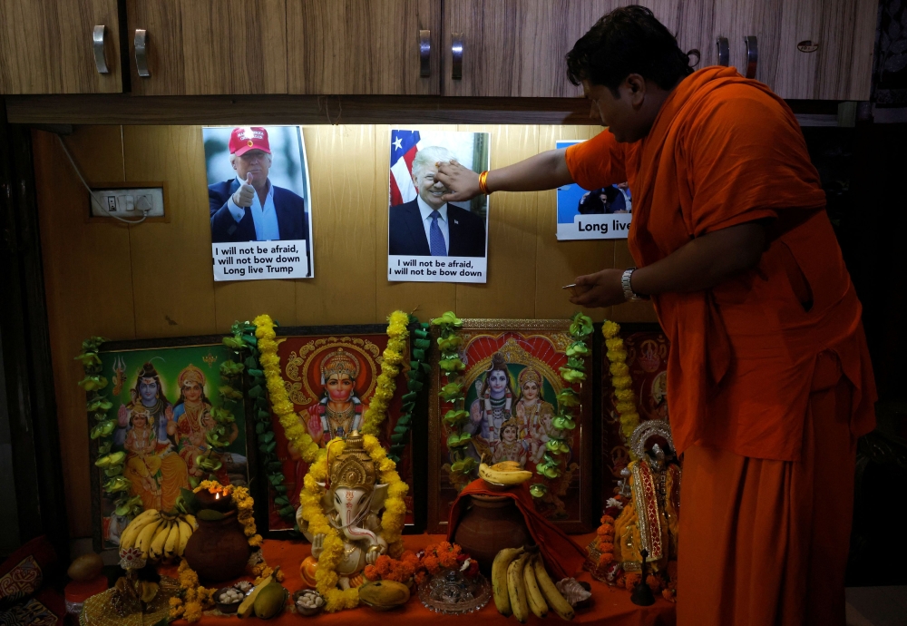 An activist from Hindu Sena, a Hindu right-wing group, applies a 'tilak' mark on a poster of Republican presidential nominee and former US President Donald Trump during a special prayer for his longevity after he survived an assassination attempt, in New Delhi, India, July 16, 2024. — Reuters pic