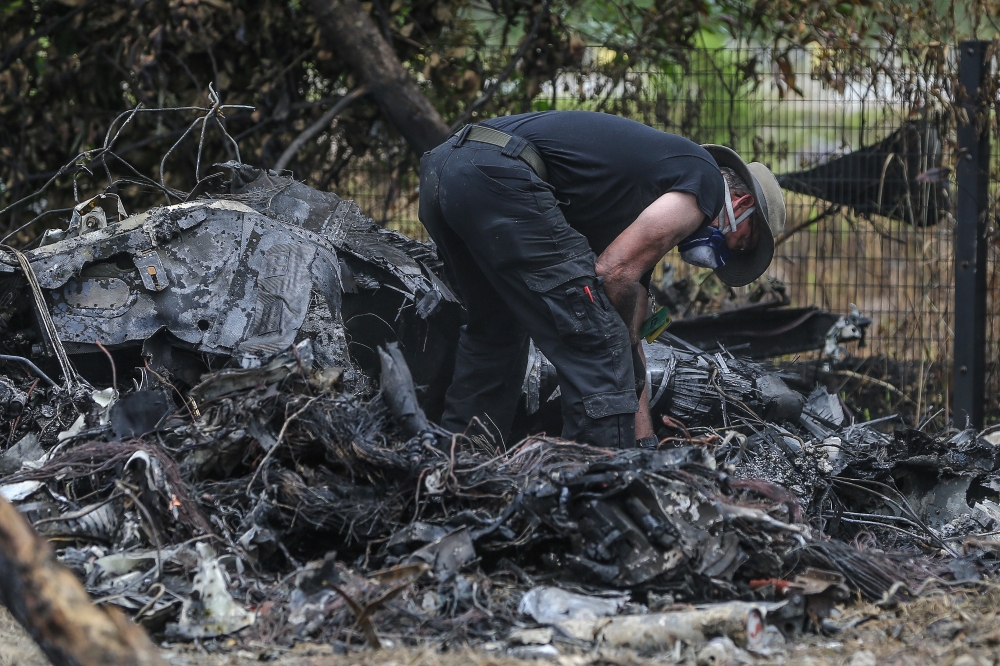Investigators from the US National Transportation Safety Board (NSTB), Federal Aviation Administration (FAA), and Beechcraft inspect debris at the site of the Elmina plane crash on August 21, 2023. — Picture by Yusof Mat Isa