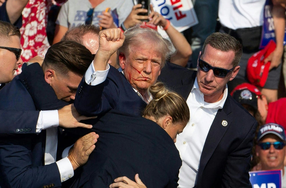 Republican candidate Donald Trump is seen with blood on his face surrounded by secret service agents as he is taken off the stage at a campaign event at Butler Farm Show Inc in Butler, Pennsylvania, July 13, 2024. — AFP pic 