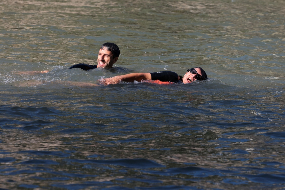 Paris Mayor Anne Hidalgo and President of the Paris 2024 Olympics and Paralympics Organising Committee Tony Estanguet swim in the Seine, to demonstrate that the river is clean enough to host the outdoor swimming events at the Paris Olympics later this month, in Paris, France, July 17, 2024. — Reuters pic 