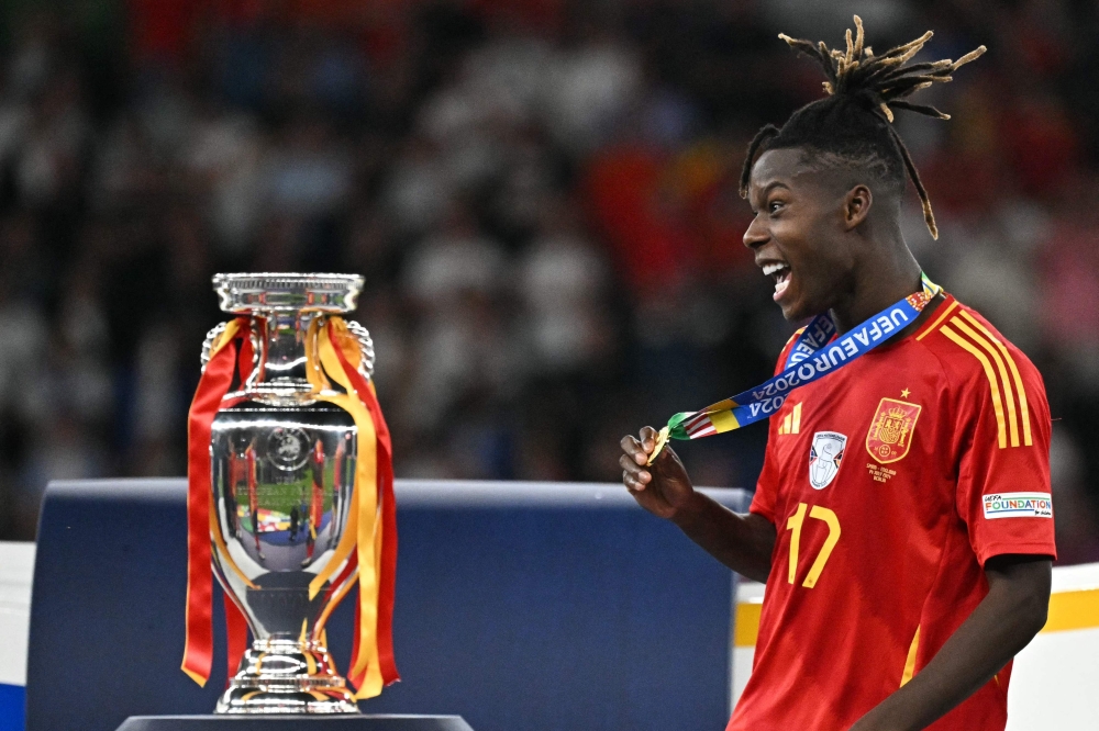 Spain’s midfielder #17 Nico Williams celebrates with his silver medal next to the trophy after winning the Uefa Euro 2024 final football match between Spain and England at the Olympiastadion in Berlin on July 14, 2024. — AFP pic