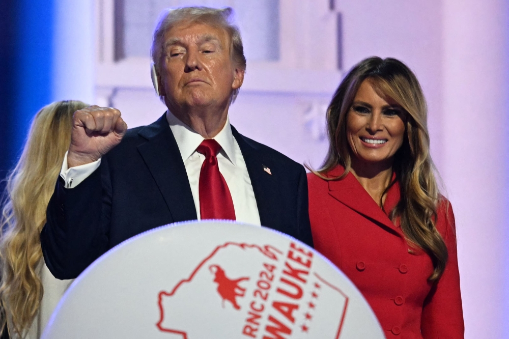 Balloons fall in front of former US President and 2024 Republican presidential candidate Donald Trump as he raises his fist next to former First Lady Melania Trump on stage after he accepted his party's nomination on the last day of the 2024 Republican National Convention at the Fiserv Forum in Milwaukee, Wisconsin July 18, 2024. — AFP pic  