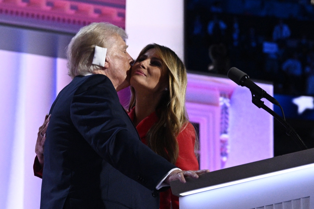 Former US First Lady Melania Trump (right) kisses US former President and 2024 Republican presidential candidate Donald Trump as she joins him onstage during the last day of the 2024 Republican National Convention at the Fiserv Forum in Milwaukee, Wisconsin, on July 18, 2024. — AFP pic