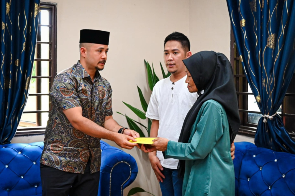 Tengku Amir Nasser Ibrahim Shah (left) hands over the donation to Nur Farah Kartini’s family. — Picture courtesy of Facebook/Kesultanan Pahang