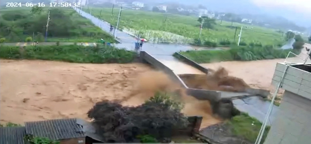A bridge collapses following heavy rainfall and flooding in Dongshi Town, Meizhou City, Guangdong Province, China June 16, 2024, in this still image obtained from social media video. ― Reuters pic