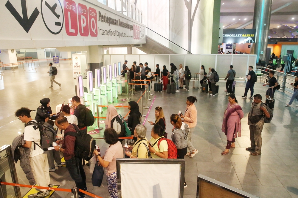 Immigration officers check passengers’ travel documents at Terminal 2 of Kuala Lumpur International Airport in Sepang July 19, 2024. — Picture by Choo Choo May.