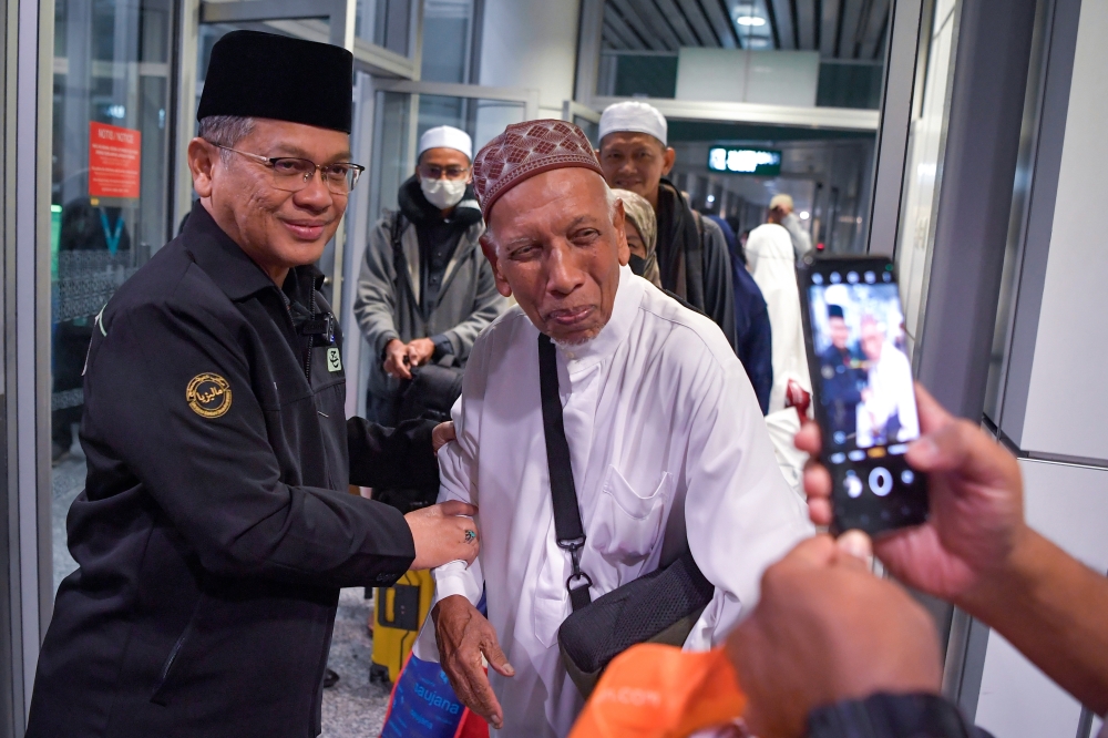 Minister Datuk Dr Mohd Na'im Mokhtar (left) greets a Malaysian haj pilgrim returning from Saudi Arabia at Terminal 1 of the Kuala Lumpur International Airport last night. — Bernama pic