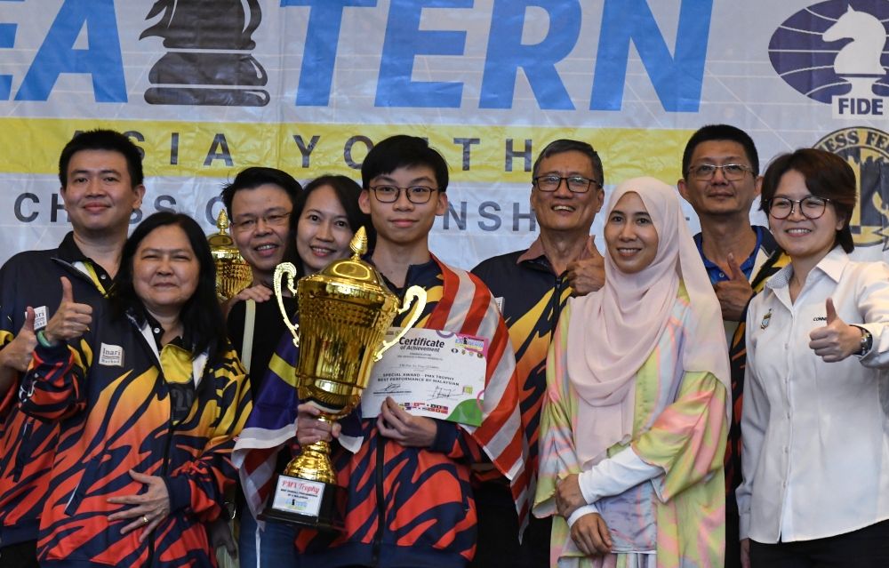 Malaysian teen Poh Yu Tian (centre) is the first recipient of the PMX Cup after winning under-18 open category in the 8th East Asian Youth Chess Championship held in George Town, Penang on July 21, 2024. — Bernama pic