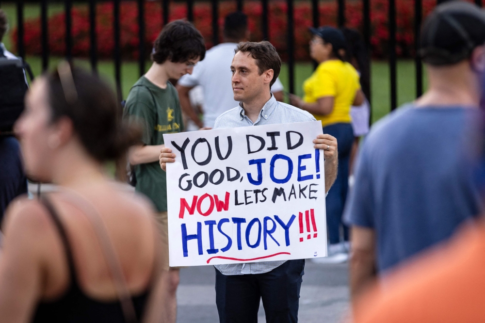 A man holds a sign showing his appreciation for US President Joe Biden along Pennsylvania Avenue in front of the White House in Washington, DC, on July 21, 2024. — AFP pic