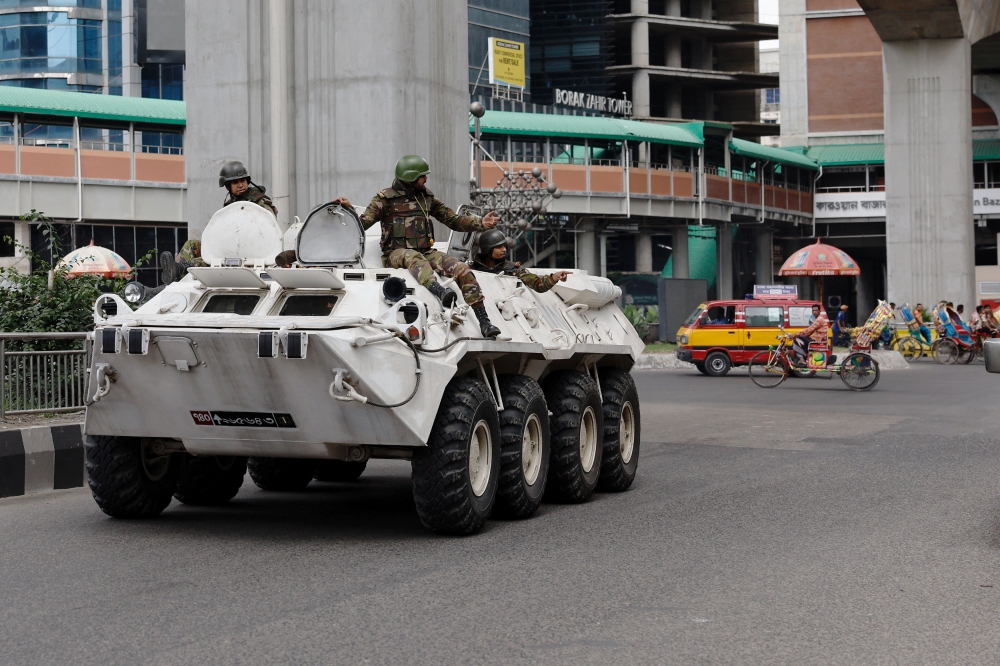 Members of the Bangladesh Army gesture as they patrol in an armoured vehicle on the second-day of curfew, as violence erupted in parts of the country after protests by students against government job quotas, in Dhaka, Bangladesh, July 21, 2024. — Reuters pic 