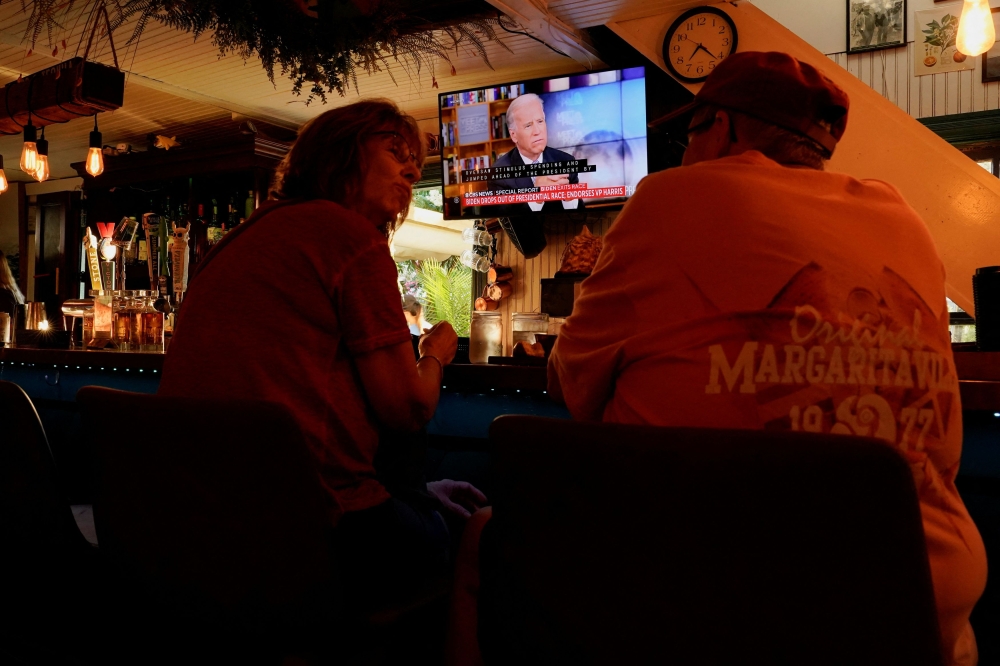 People sit at a restaurant called Somewhere where US President Joe Biden can be seen on a TV screen, on the day he announced he is stopping his bid for reelection, in Rehoboth Beach, Delaware, July 21, 2024. — Reuters pic