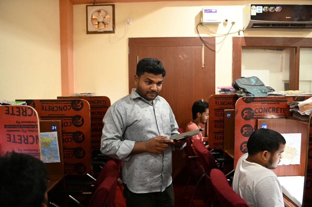 Sunil Kumar, 30, inspects inside Shree Chaitanya, a digital student library, where he works as a part-time manager as he prepares for competitive exams to secure a government job in Prayagraj, India, June 19, 2024. — Reuters pic  