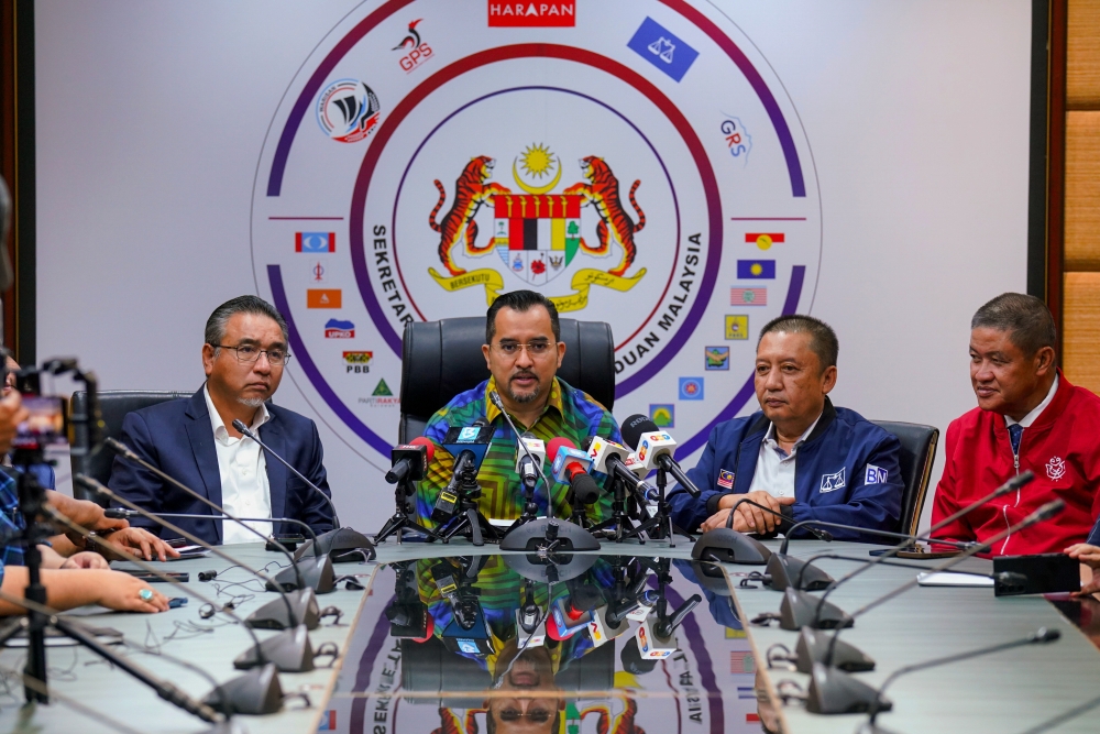 Unity government secretariat chief Datuk Asyraf Wajdi Dusuki speaks at a press conference after the BN-PH Coordination Meeting for the Nenggiri state by-election at Menara Dato Onn, July 22, 2024. Also present was Deputy Minister of Defence Adly Zahari (left) who is the Kelantan PH election operations director and BN election operations director Datuk Ahmad Jazlan Yaakub (right) as well as representatives from Kelantan BN and PH. — Bernama pic 