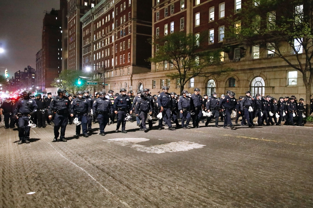 NYPD officers in riot gear march onto Columbia University campus, where pro-Palestinian students are barricaded inside a building and have set up an encampment, in New York City April 30, 2024. — AFP pic