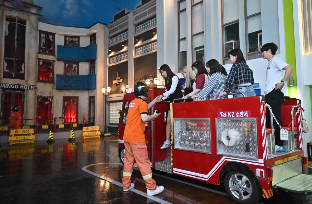 Visitors role-playing as firefighters during an adult-only event at KidZania, a children’s job experience theme park, in Seoul June 28, 2024. — AFP pic