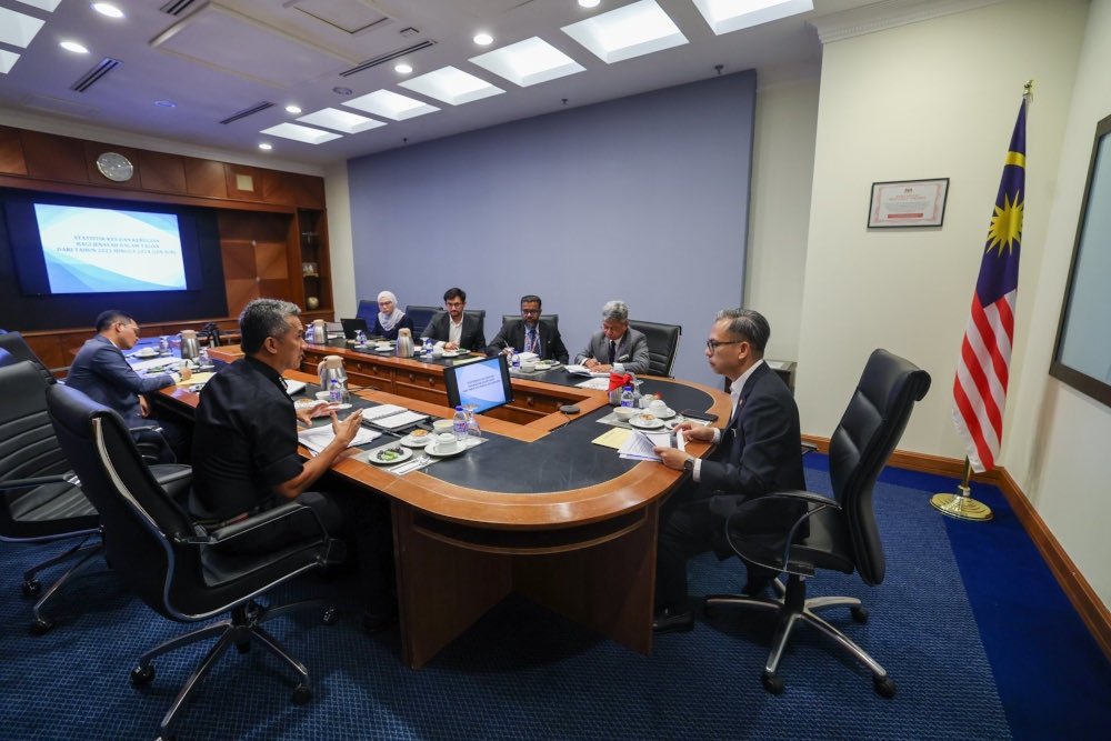 Communications Minister Fahmi Fadzil and Bukit Aman Criminal Investigation Department director Datuk Seri Mohd Shuhaily Mohd Zain and a deputy director of the Commercial Crime Investigation Department during a briefing in Kuala Lumpur, July 24, 2024. Also present is National Security Council director-general Datuk Raja Nurshirwan Zainal Abidin. — Picture from X/Fahmi Fadzil 