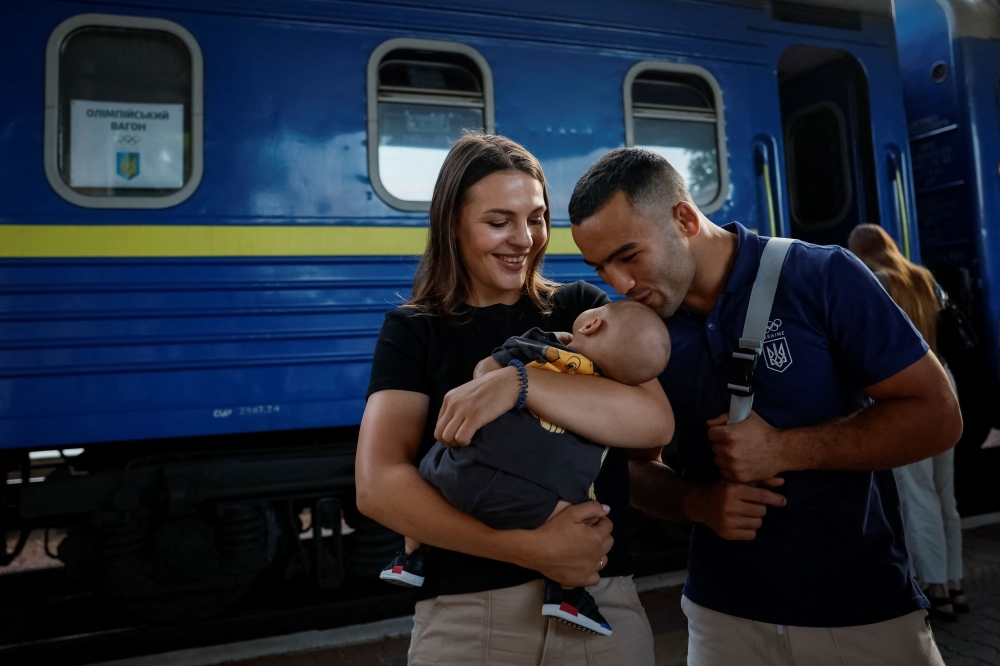 A silver medallist of 2020 Tokyo Olympics and a member of the Ukrainian Olympic wrestling team Parviz Nasibov says goodbye to his family before boarding a train to the Paris 2024  Olympics via Poland, amid Russia's attack on Ukraine, in Kyiv. —Reuters pic