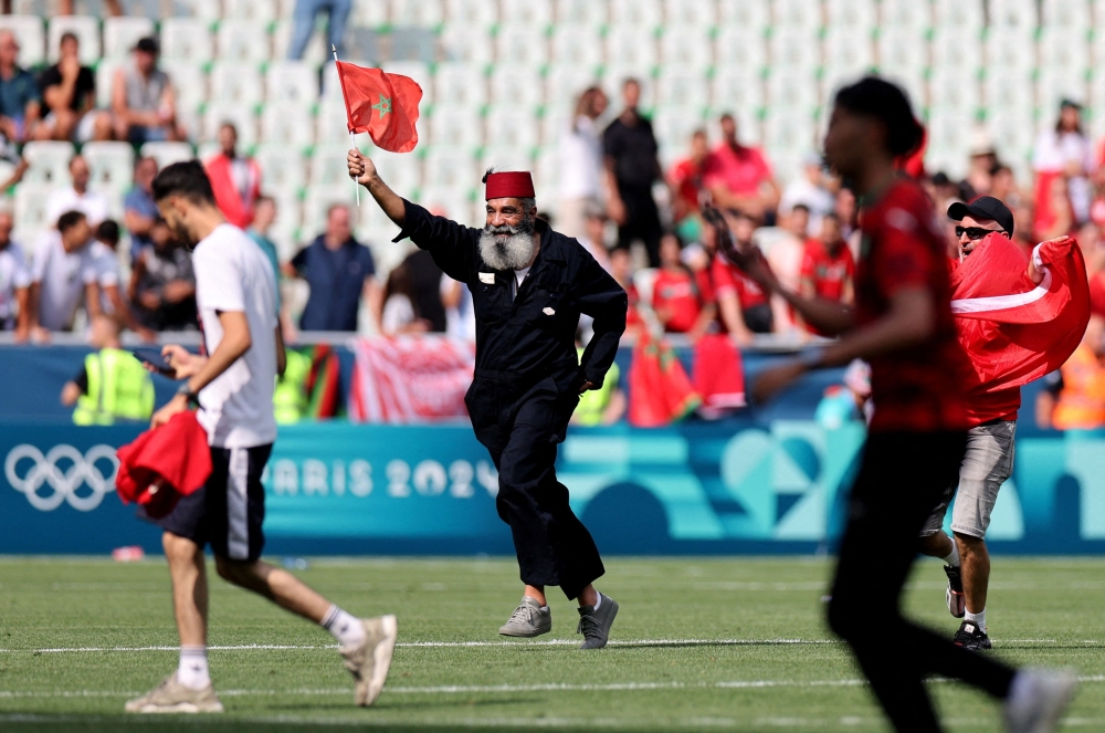 A fan invaded the opening match of the Olympic football tournament between Argentina and Morocco yesterday. — Reuters pic 
