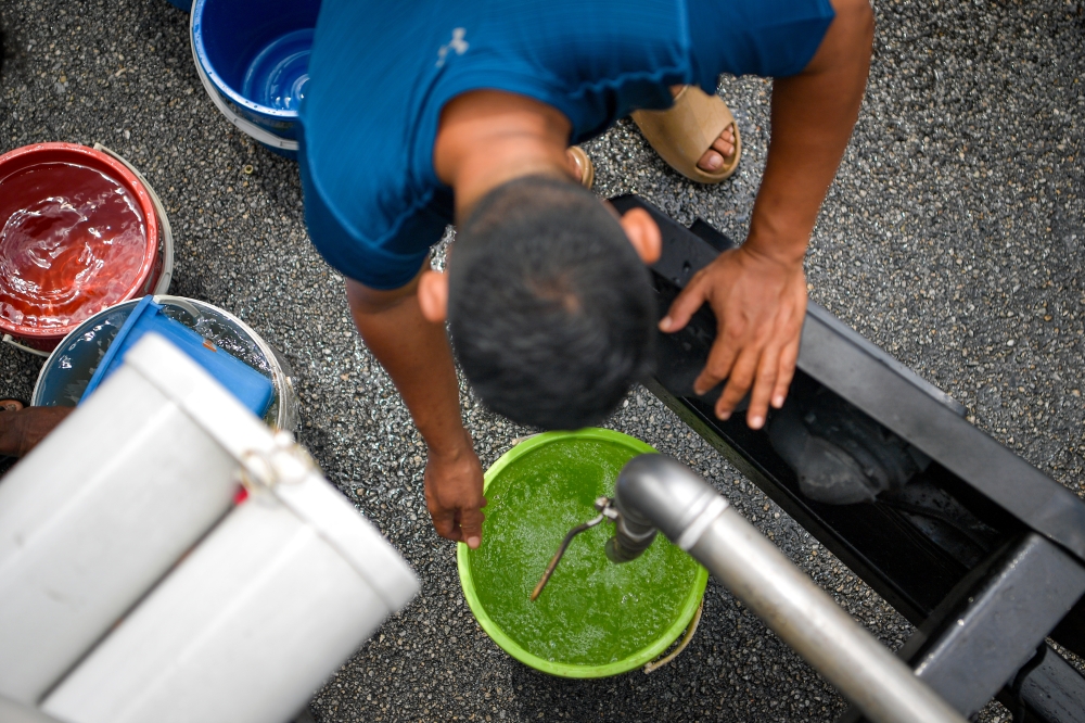 File picture of residents of Sri Hartamas collect water for their clean water supply following the supply disruption due to an odour pollution incident at Sungai Kundang and Sungai Sembah, July 22, 2024. — Bernama pic 