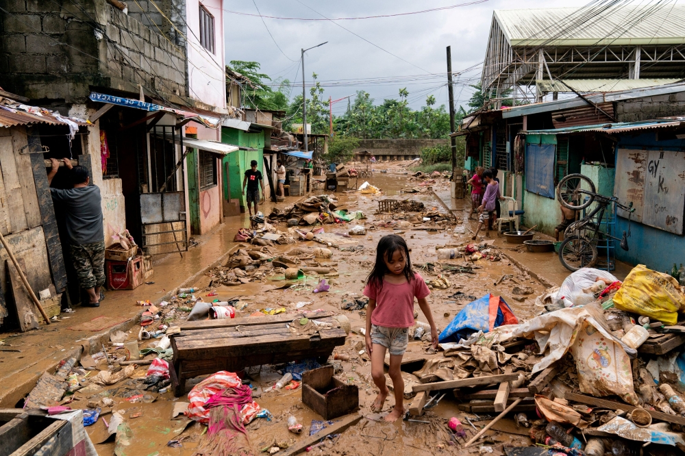 A girl walks past debris and mud following the floods brought by Typhoon Gaemi, in Marikina City, Metro Manila, July 25, 2024. — Reuters pic