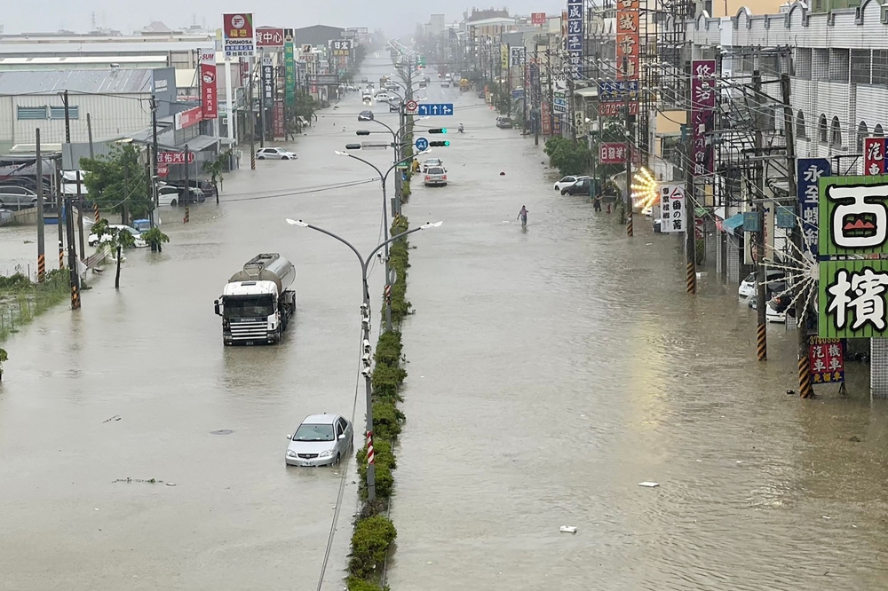 Vehicles wade through the water along a street that was flooded by Typhoon Gaemi in Kaohsiung on July 25, 2024.— AFP pic