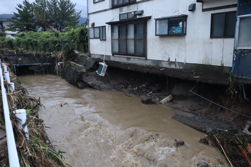 A house with a collapsed foundation is seen following heavy rains in Nikaho City, Akita prefecture on July 25, 2024. At least three people were missing in Japan on July 26, after heavy rains caused rivers to burst their banks, washing away cars and prompting several thousand locals to evacuate, authorities and media reports said. Local governments in the northern prefectures of Yamagata and Akita issued evacuation advisories to more than 200,000 people, the fire and disaster management agency said. — Japan OUT pic via AFP 
