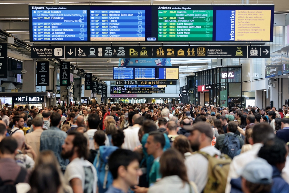 Passengers gather around the departure and arrival boards at the Gare Montparnasse train station in Paris on July 26, 2024 as France’s high-speed rail network was hit by malicious acts disrupting the transport system hours before the opening ceremony of the Paris 2024 Olympic Games. — AFP pic 