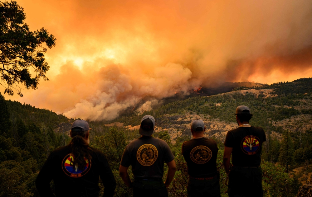 Firefighters watch as flames and smoke move through a valley in the Forest Ranch area of Butte County as the Park Fire continues to burn near Chico, California, on July 26, 2024. — AFP pic 