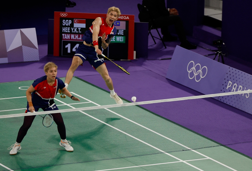 Tang Jie Chen and Ee Wei Toh of Malaysia in action during the group D match against Yong Kai Terry Hee of Singapore and Wei Han Jessica Tan of Singapore at the Porte de La Chapelle Arena, Paris, July 27, 2024. — Reuters pic 