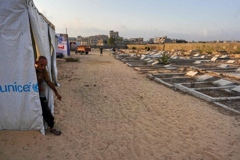 Displaced Palestinians from the eastern part of Khan Yunis, set up a temporary camp in the grounds of a cemetery in the western part of the city, in the southern Gaza Strip, on July 26, 2024. — AFP pic 