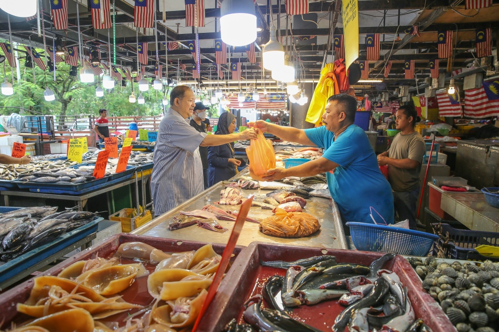 A man buys fish at Pasar Awam Moden Seksyen 6 in Shah Alam September 26, 2023. — Picture by Yusof Mat Isa