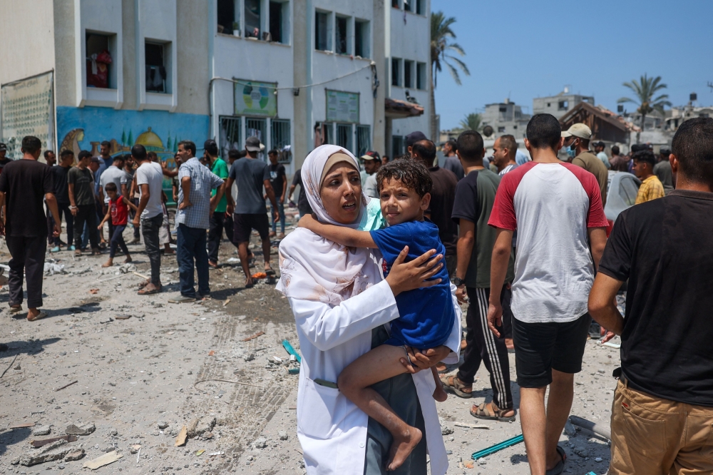 Palestinians inspect the damage following an Israeli strike on the Khadija school housing displaced people in Deir al-Balah, in the central Gaza Strip on July 27, 2024. — AFP pic