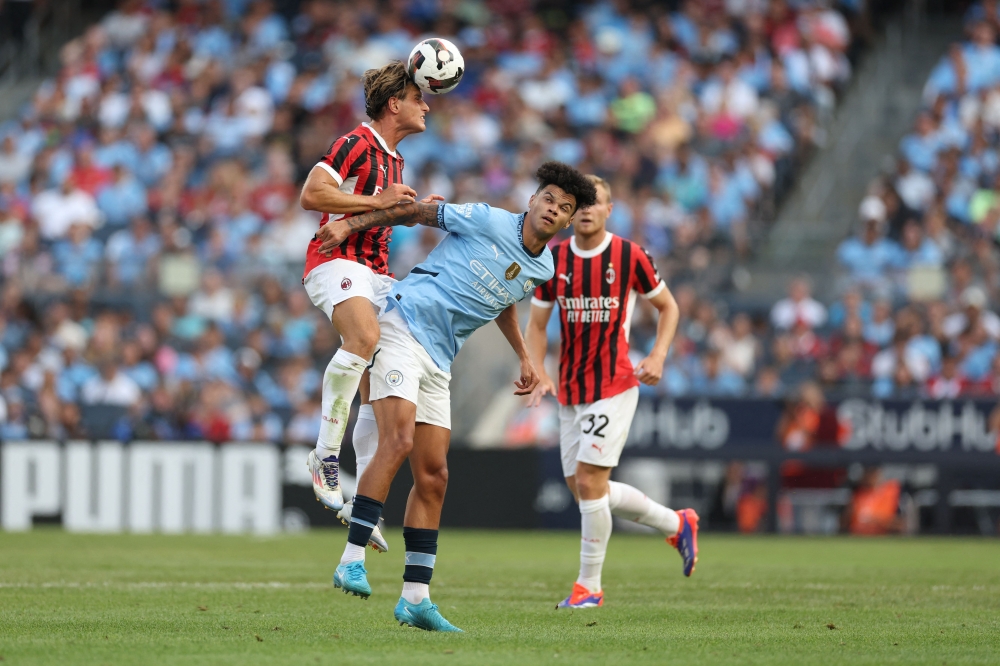 AC Milan’s Italian forward Lorenzo Colombo (left) fights for the ball with Manchester City's English midfielder Nico O’Reilly during the pre-season club friendly football match between Manchester City and AC Milan at the Yankee Stadium in New York on July 27, 2024. — AFP pic