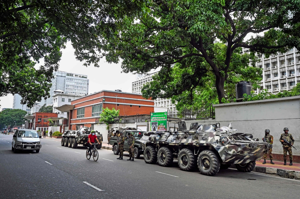 Bangladeshi soldiers stand guard outside the nation’s Secretariat in Dhaka as curfew is relaxed after student-led protests over limited public sector jobs. — AFP pic