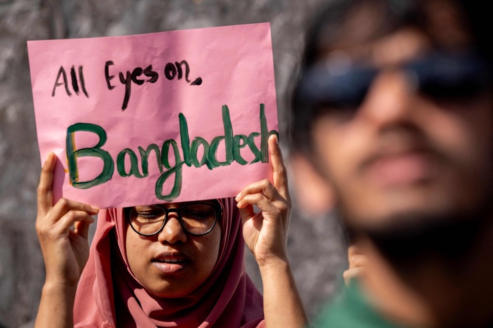 A demonstrator in Copenhagen, Denmark holds up a placard in solidarity with university students in Bangladesh protesting a public sector quota hiring system. — AFP pic