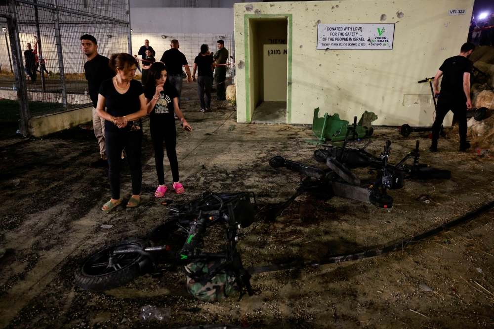 People look at the damage after rockets were launched across Lebanon's border with Israel which, according to Israel's ambulance services killed people, at a soccer pitch in Majdal Shams, a Druze village in the Israeli-occupied Golan Heights, July 27, 2024. — Reuters pic