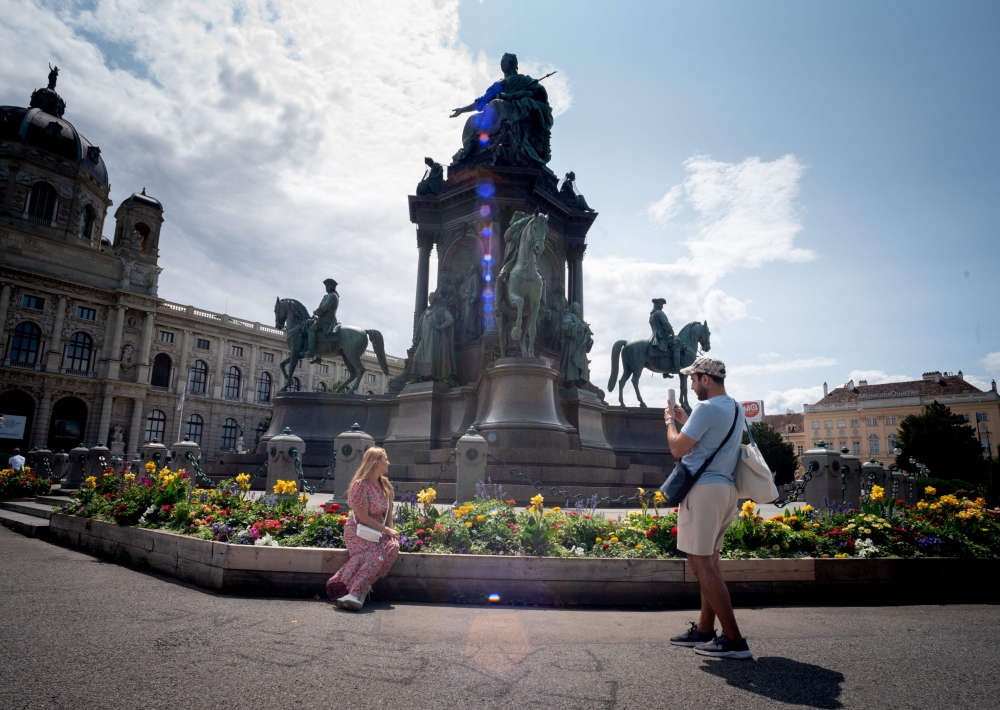 A couple snaps photographs in front of the Maria Theresa Memorial in Vienna, Austria, on July, 24 2024. The Maria Theresa Memorial, designed by Baron Karl von Hasenauer and Gottfried Semper, is one of the important monuments of the Habsburg monarchy. Empress Maria Theresa ruled from 1740 to 1780. — AFP pic