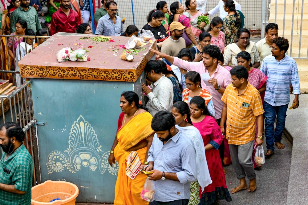 In this photo taken on July 24, 2024, Hindu devotees walk around the inner chamber of Chilkur Balaji temple popularly known as 'Visa Balaji Temple' at Chilkur village, Rangareddy district about 30 kms from Hyderabad. Some gods grant riches and others good luck, but one deity in India offers a much less nebulous fortune to his devotees: tickets to a new life in the United States. More than 1,000 Hindu faithful visit the Chilkur Balaji temple each day in the belief that the divine presence inside can bless worshippers with a successful visa application. — AFP pic