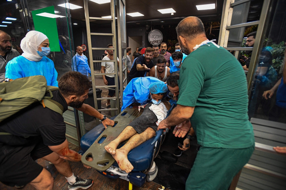 Medical staff shown receiving an injured person at the Bahman hospital following an Israeli military strike on a building in Beirut's southern suburb. July 30, 2024. — AFP pic