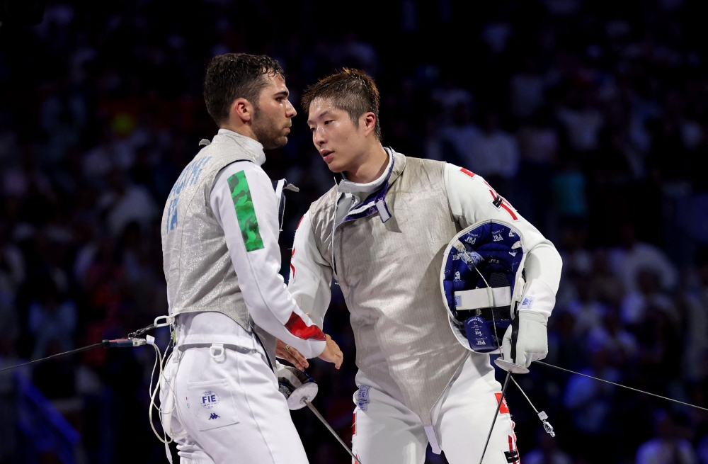  Ka Long Cheung of Hong Kong shakes hands with Filippo Macchi of Italy after winning gold medal bout.— Reuters pic
