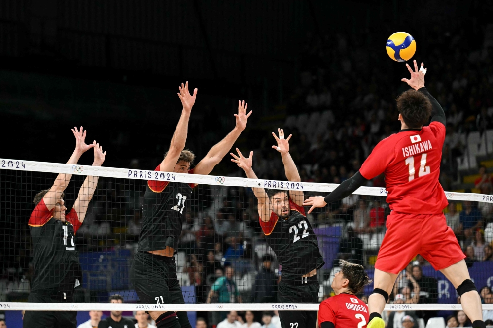 Japan's #14 Yuki Ishikawa (right) spikes the ball during the men's preliminary round volleyball match between Japan and Germany during the Paris 2024 Olympic Games at the South Paris Arena 1 in Paris on July 27, 2024. — AFP pic